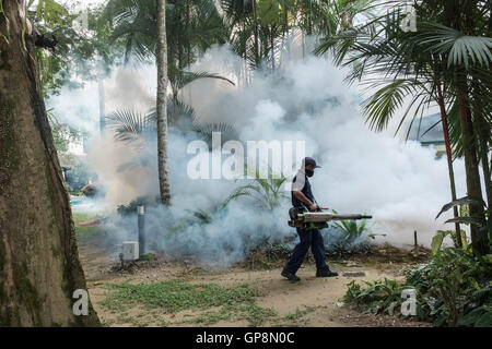 Ein Arbeiter Nebel gegen Mücken um eine Eigentumswohnung in Kuala Lumpur, Malaysia. Stockfoto