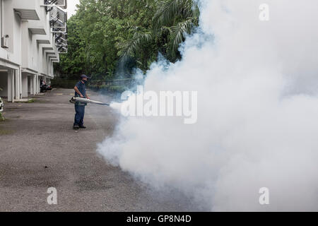 Ein Arbeiter Nebel gegen Mücken um eine Eigentumswohnung in Kuala Lumpur, Malaysia. Stockfoto