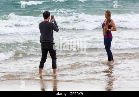 Bournemouth, Dorset, UK 3. September 2016. Menschen nehmen Foto hübsche junge Frau an einem kalten, grauen Tag am Strand von Bournemouth mit Duschen, Regen und abgehackt Meere Credit: Carolyn Jenkins/Alamy Live News Stockfoto