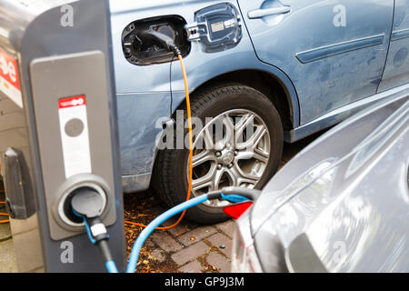 Elektro-Autos geparkt und an eine Ladestation in Amsterdam Holland Niederlande Stockfoto