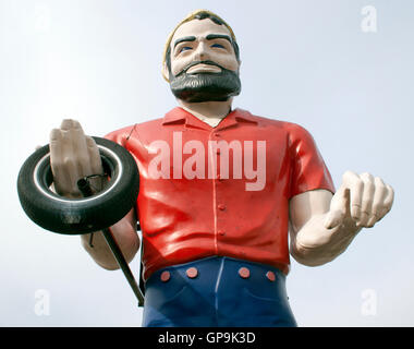 Der Schalldämpfer hält einen Reifen und steht hoch in Atlanta, Georgia, einem klassischen Riesen am Straßenrand, der die Vintage-Americana und die Autokultur symbolisiert. Stockfoto