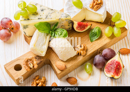 Käseplatte mit Feigen, Trauben und Nüssen Stockfoto