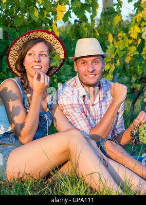 Glückliches Paar essen frische Trauben im Weinberg Stockfoto