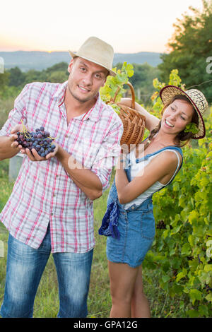 Paar auf einem Weingut hält einen Weidenkorb. Weinlese Stockfoto