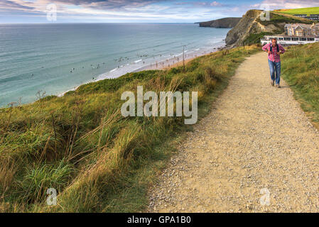Ein Wanderer auf dem South West Coastal Path in der Nähe von Watergate Bay in Cornwall. Stockfoto