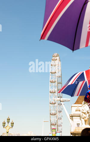 London, UK - 30. August 2016: London Eye im Hintergrund des de-fokussierte Schirme mit England Flagge. Stockfoto