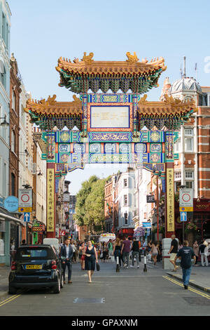 London, England - 30. August 2016: Menschen fahren durch das neue chinesische Tor auf Wardour Street in Chinatown. Stockfoto