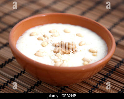 Haferflocken-Porridge mit Sesam, Walnüssen und Pinienkernen auf braune Bambusmatte Stockfoto