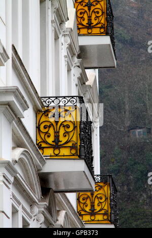 Alte Gebäude-Fragment mit gelben schmiedeeisernen Balkonen im Schnee. Stockfoto