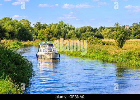 Weiße Motorboot gemütlichen Cruisen auf den Wey Navigation in der Nähe von senden, Surrey an einem sonnigen Tag mit blauem Himmel im Sommer Stockfoto