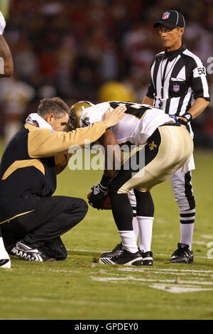 20. September 2010; San Francisco, CA, USA;  New Orleans Saints Runningback Reggie Bush (25) wird besucht, um durch Trainer nach Erhalt einer Beinverletzung auf einem Kahn gegen die San Francisco 49ers im vierten Quartal im Candlestick Park zurückzukehren. Neue Orle Stockfoto