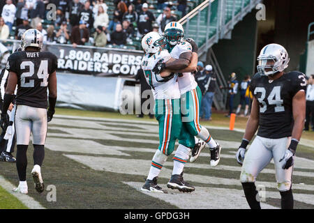 November 2010; Oakland, CA, USA; Miami Dolphins Running Back Ricky Williams (34) feiert mit dem Offensive Tackle Jake Long (77), nachdem er im vierten Quartal im Oakland-Alameda County Coliseum einen Touchdown gegen die Oakland Raiders erzielt hatte. Miami Stockfoto