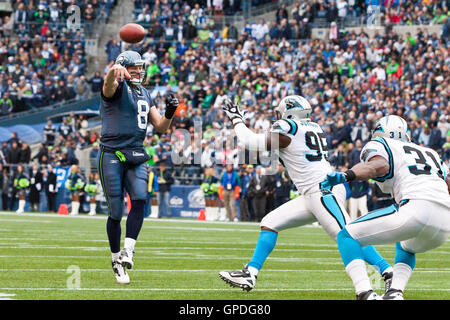 5. Dezember 2010; Seattle, WA, USA;  Seattle Seahawks Quarterback Matt Hasselbeck (8) wirft einen Pass über Carolina Panthers Defensive end Charles Johnson (95) und Cornerback Richard Marshall (31) im zweiten Quartal bei Qwest Field. Seattle besiegt Ca Stockfoto