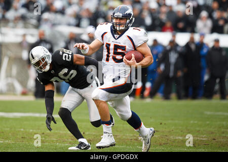 19. Dezember 2010; Oakland, Kalifornien, USA;  Denver Broncos Quarterback Tim Tebow (15) eilt vorbei an Oakland Raiders Cornerback Stanford Routt (26) für einen Touchdown im ersten Quartal im Oakland-Alameda County Coliseum. Stockfoto