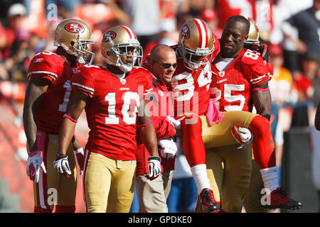 Okt 9, 2011; San Francisco, Ca, USA; San Francisco 49ers wide receiver Josh Morgan (84) auf OFF (AUS) steht das Feld durch Mannschaftskameraden und medizinisches Personal nach Erhalt einer Verletzung gegen die Tampa Bay Buccaneers im vierten Quartal bei Candlestick Park. San Stockfoto