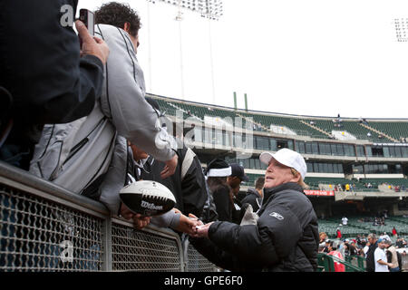 Dezember 2011; Oakland, CA, USA; Mark Davis, Besitzer der Oakland Raiders (rechts), unterzeichnet Autogramme vor dem Spiel gegen die Detroit Lions im O.Co Coliseum. Detroit besiegte Oakland mit 28:27. Stockfoto
