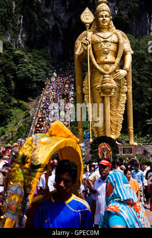 Menschen steigen die Stufen neben der Statue von Lord Murugan auf dem Thaipusam-Festival in Batu Caves, Malaysia. Stockfoto