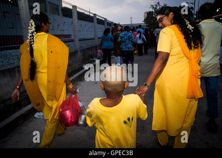 Ein Kind getroffen, um die Prozession von zwei Frauen auf dem Thaipusam-Festival in Batu Caves, Malaysia. Stockfoto