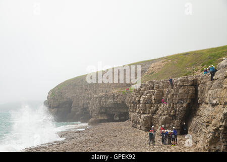 Schülerinnen und Schüler in Richtung auf den Klippen in der Nähe von Dancing Ledge Dorset klettern. Stockfoto