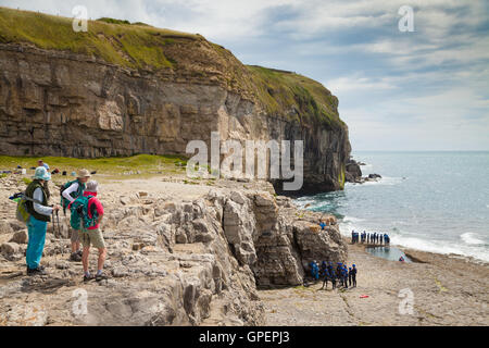 Wanderer mit Blick auf Schülerinnen und Schüler auf den Weg um zu Coasteering auf Dancing Ledge Dorset zu tun. Stockfoto