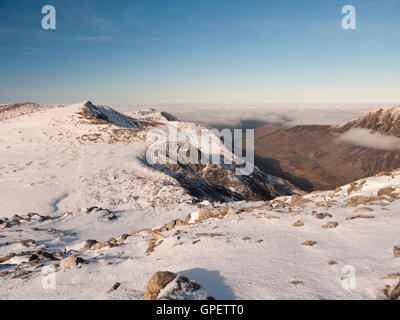 Eine schneebedeckte Y Garn im Winter, betrachtet von Glyder Fawr wie eine Wolke Inversion Nant Ffrancon fegt. Snowdonia-Nationalpark Stockfoto