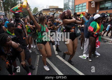 Auf Kensal Straße, die verschiedenen Gruppen der Tänzer auf der Parade am Sonntag, 28. August 2016 bei den 50. Notting Hill Carnival in Westlondon. Ein Fest der Westindischen / Karibik Kultur und Europas größte Straßenparty, Festival und Parade. Nachtschwärmer kommen in hunderttausenden zum Spaß haben, tanzen, trinken und loslassen in die tolle Atmosphäre. Es wird geführt von den Mitgliedern der West-indischen / Karibische Gemeinschaft, besonders die Trinidad und Tobagonian britische Bevölkerung, von denen viele seit den 1950er Jahren in der Gegend gelebt haben. Der Karneval hat in der Vergangenheit und c bis zu 2 Millionen Menschen angezogen. Stockfoto