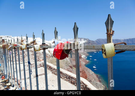 Mehrfarbige Liebhaber Vorhängeschlösser zieren eine Reihe von Geländer in die Stadt Oia auf der schönsten und romantischsten griechischen Insel Santorini. Stockfoto