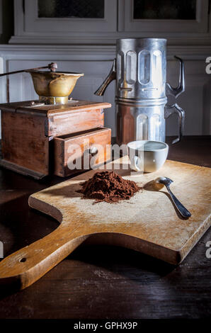 Stillleben mit einer Kaffeemühle ein einer neapolitanischen Kaffee Moka und eine weiße Tasse und Stahl kleinen Löffel neben einem Haufen von Kaffee-Pulver Stockfoto