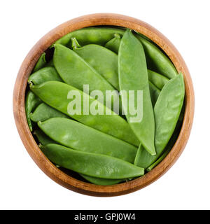 Zuckerschoten in einer Holzschale auf weißem Hintergrund. Pisum Sativum Saccharatum, eine grüne Hülsenfrucht und Vielfalt der Erbse, ganz gegessen. Stockfoto