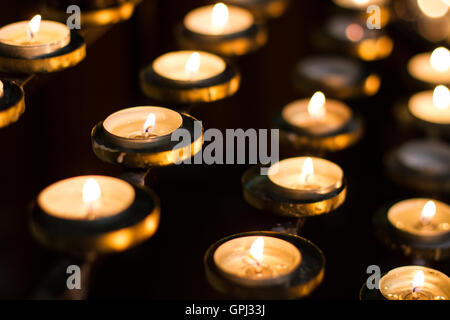 Zeilen von beleuchteten Kirche Kerzen im Gedenken an die Toten und Lieben. Stockfoto