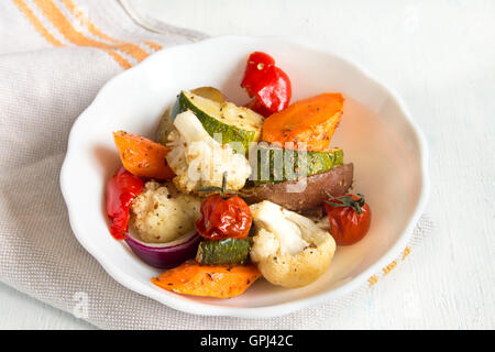 Rustikalen Ofen gebackenes Gemüse mit Gewürzen und Kräutern in weiße Schüssel hautnah, vegetarisches Bio Herbst Menü Stockfoto