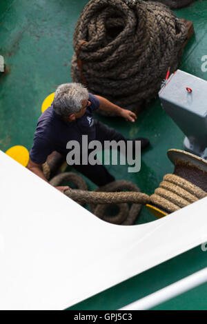 Griechische Fähre Besatzung vor dem Andocken am Hafen. Guiding Liegeplatz Seil beim Andocken Verfahren. Stockfoto