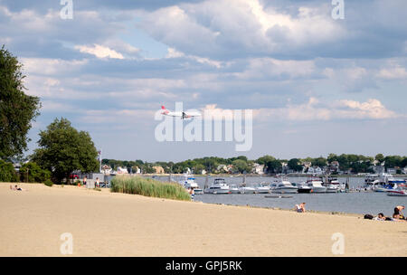 Virgin America Jet fliegen über Verfassung Strand im Orient Heights und über den Boden am Boston Logan International Airport, U Stockfoto