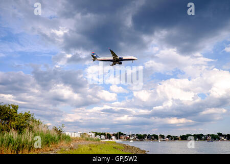 US Airways Jet fliegen über Orient Heights und über den Boden an der Boston Logan International Airport, USA Stockfoto