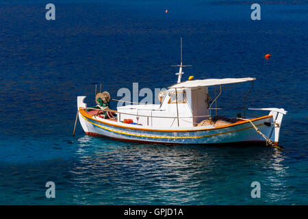 Traditionellen hölzernen Fischerboot schwimmt auf den bunten Gewässern am Nachmittag gegen das blaue Wasser, Lakonia, Griechenland Stockfoto
