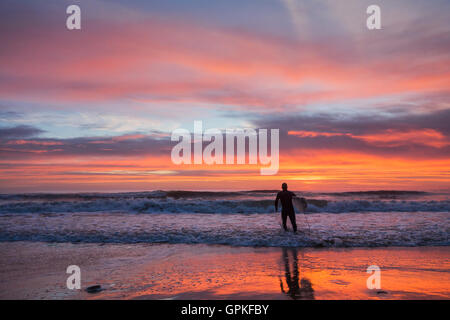 Surfer bei Sonnenaufgang bei Seaton Carew, Nordostengland, Großbritannien, Stockfoto