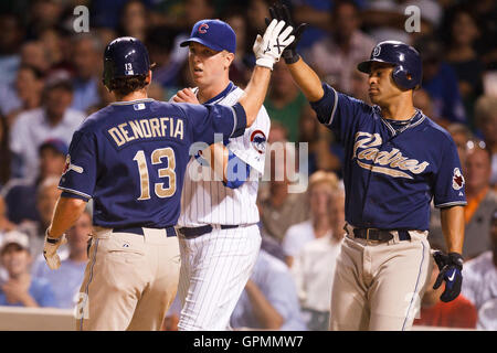 16. August 2010; Chicago, IL, USA;  San Diego Padres linker Feldspieler Chris Denorfia (13) ist durch Shortstop Jerry Hairston Jr. (rechts) vor Chicago Cubs ab Pitcher Tom Gorzelanny (Mitte), nach seinem Tor einen Lauf während der fünften Inning am gratulierte Stockfoto