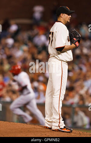 24. August 2010; San Francisco, CA, USA;  San Francisco Giants starten Krug Jonathan Sanchez (57) Uhren als Cincinnati Reds zweiter Basisspieler Brandon Phillips (hinten) runden die Grundlagen nach der Kollision mit seinen zweiten run Home Run des Spiels während der fünften Stockfoto