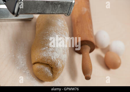 Hausgemachte Dinkel-Teig für Nudeln auf Holztisch und Eiern im Hintergrund. Stockfoto