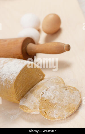 Hausgemachte Dinkel-Teig für Nudeln auf Holztisch und Eiern im Hintergrund. Stockfoto