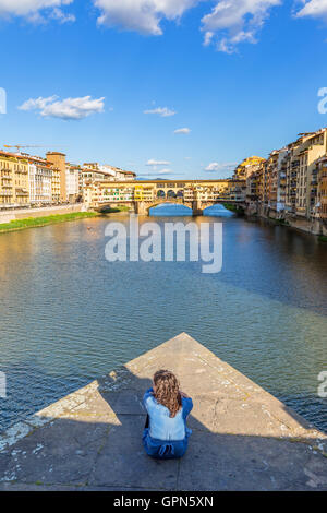 Frau auf einer Brücke in Florenz mit Blick auf die Ponte Vecchio Brücke Stockfoto