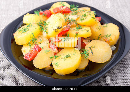 Eintopf aus Kartoffeln mit Zwiebeln, Paprika und Fenchel auf der Oberfläche des Tisches auf Tischdecke Hintergrund Stockfoto