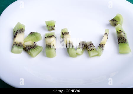 Ansicht-close-up auf das Wort Kiwi, Buchstaben bestehend aus Kiwi-Früchte auf einen leeren weißen Teller Stockfoto