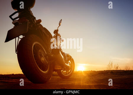 Motorrad steht auf Sonnenuntergang Hintergrund Stockfoto