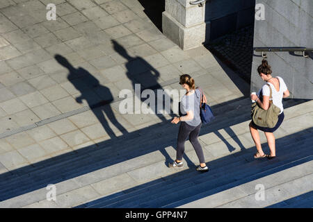 2 Frauen laufen auf Schritte, lange Schatten in Linz, Oberösterreich, Oberösterreich, Österreich Stockfoto