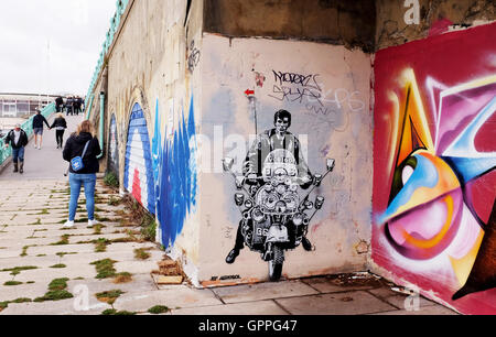 Tribut Graffiti Kunst auf eine Mod auf einem Roller durch Künstler Jef Aerosol entlang der Bögen an Brighton Seafront Stockfoto