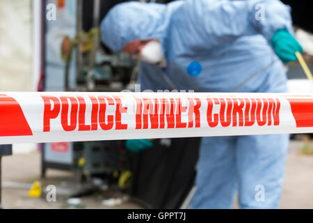 Polizei innere cordon Band Barriere und eine Szene des Verbrechens Officer / Offiziere & Beweise Identifikation Zahl Marker / Marker. UK Stockfoto