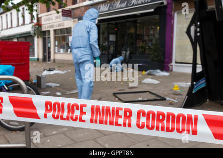 Polizei innere cordon Band Barriere und eine Szene des Verbrechens Officer / Offiziere & Beweise Identifikation Zahl Marker / Marker. UK Stockfoto