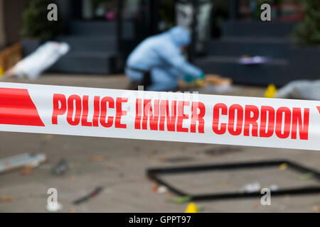 Polizei innere cordon Band Barriere und eine Szene des Verbrechens Officer / Offiziere & Beweise Identifikation Zahl Marker / Marker. UK Stockfoto