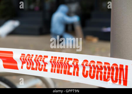 Polizei innere cordon Band Barriere und eine Szene des Verbrechens Officer / Offiziere & Beweise Identifikation Zahl Marker / Marker. UK Stockfoto